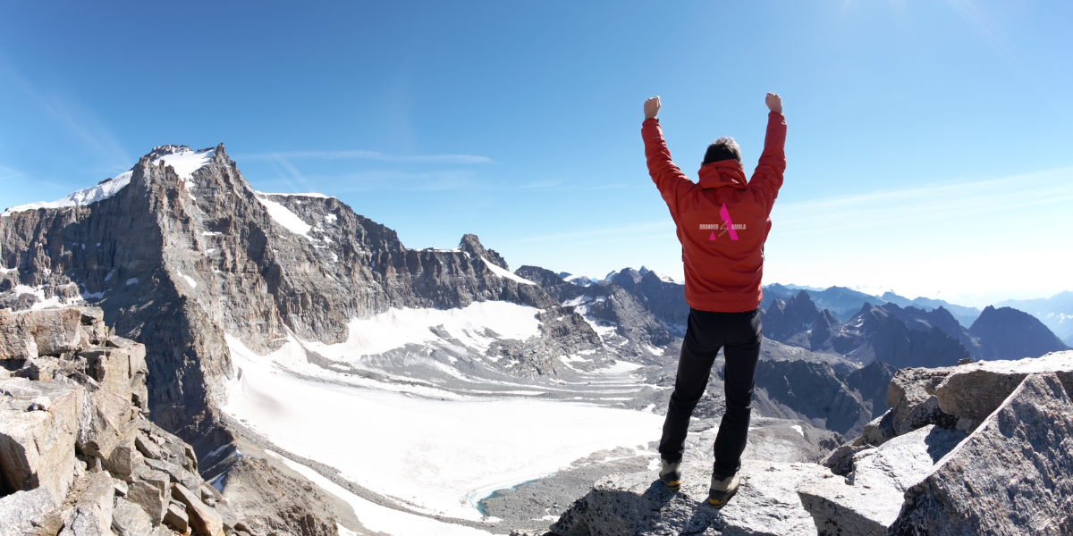 Someone celebrating with their hands in the air at the mountaintop